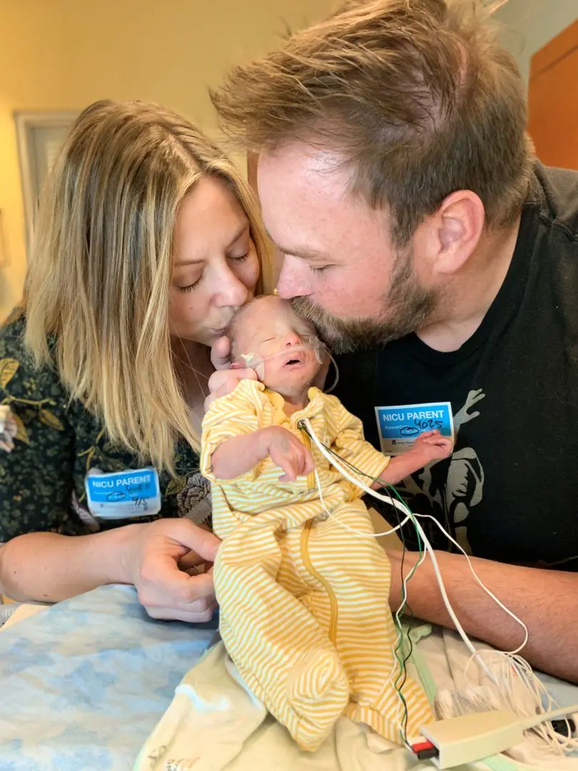 Sean and Shelley Endlsey giving their son Rowan a kiss on the forehead